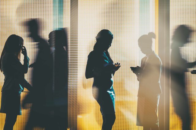 image of Silhouettes of a group of business people standing or walking in the office building
